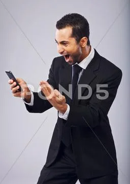 Businessman screaming in excitement while reading sms Stock Photos