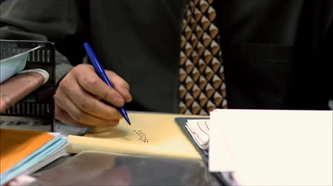 Businessman seated at desk, jotting figures Video stock 59239434