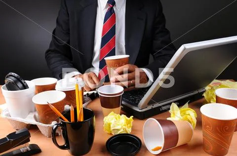 Businessman seated at his messy desk Stock Photos