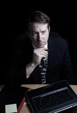 Businessman with serious look checking data late at night Stock Photos