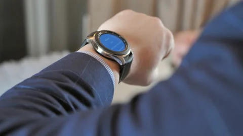 Businessman sets up a smart watch before going to work Stock Footage 125934393