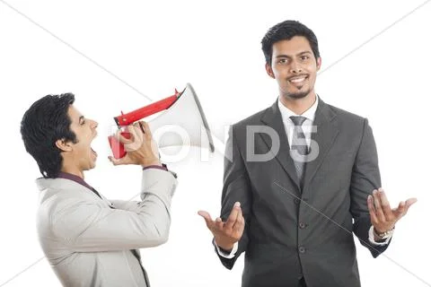 Businessman shouting on his colleague with a megaphone Stock Photos