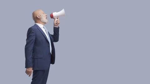 Businessman shouting a message using a megaphone Stock Photos
