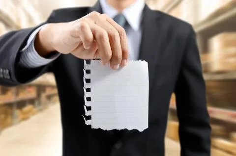 Businessman show task list on notepad with warehouse background Stock Photos