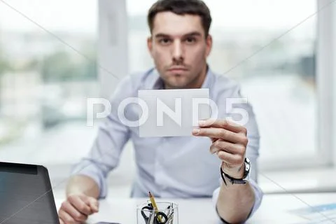 Businessman showing blank paper card at office Stock Photos