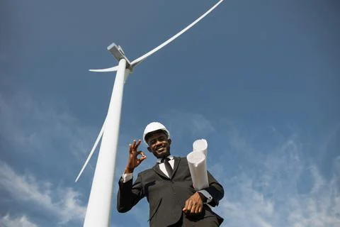 Businessman showing thumb up while posing on windmill farm 스톡 사진