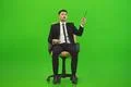 The businessman sit of the chair and gesture on the green background Photo