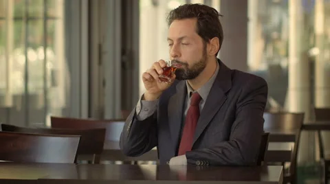 Businessman sitting alone and drinking alcohol to forget his problems Stock Footage 48894234