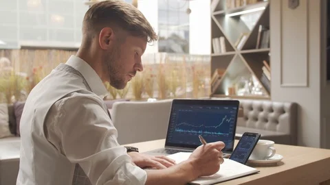 Businessman sitting and working in a cafe. Man using computer devices. Business Stock Footage 118599088