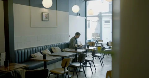 Businessman sitting and working in empty cafe restaurant on laptop. Man using Video stock 128974389