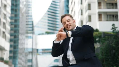 Businessman sitting at bench while talking to manager by using phone. Urbane. Stock Photos