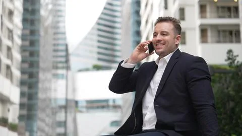 Businessman sitting at bench while talking to manager by using phone. Urbane. 스톡 사진