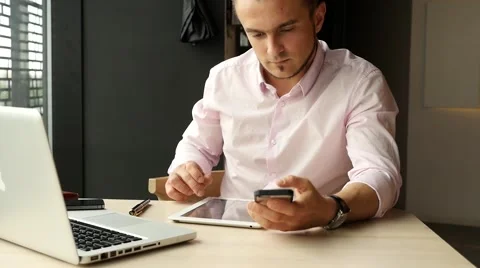 Businessman sitting in cafe with laptop, using tablet pc. Indoor photo. Stock Footage 55653724
