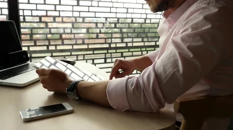 Businessman sitting in cafe with laptop, using tablet pc and drinking coffee Stock Footage 55653983