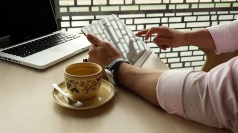 Businessman sitting in cafe with laptop, using tablet pc. Indoor photo. Stock Footage 56148955