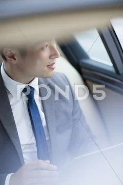 Businessman Sitting In Car Back Seat
