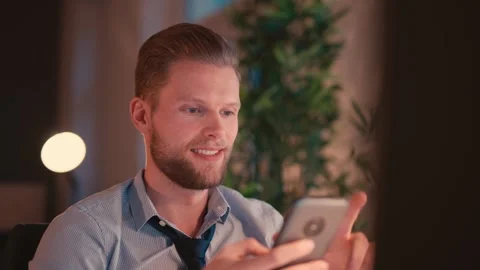 Businessman Sitting at Computer and Checking Smartphone Video stock 307763099