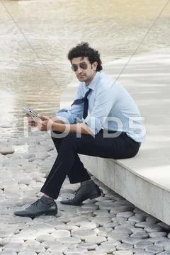 Businessman sitting in a garden and looking sad Stock Photos