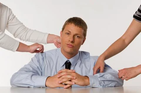 Businessman sitting, hands of two persons touching him Stock Photos