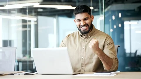 Businessman sitting at office desk smiling happily after reading good news  Stock Footage 329052376