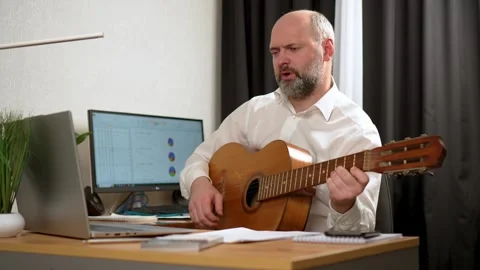 Businessman sitting at office, while playing acoustic guitar. man having break Stock Footage 269331822