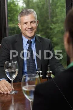 A businessman sitting opposite a colleague at a restaurant Stock Photos