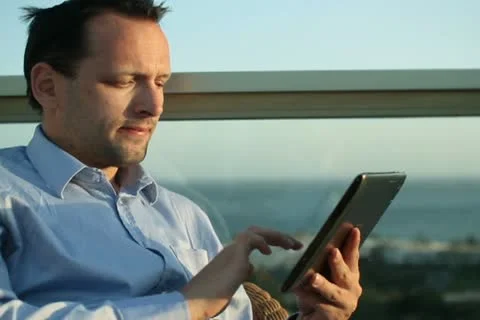 Businessman sitting outdoors and using tablet computer NTSC Stock Footage