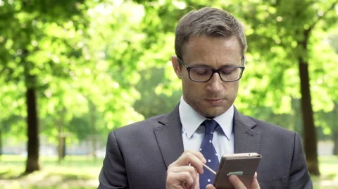 Businessman sitting in the park and using smartphone Stock-Footage 54590731