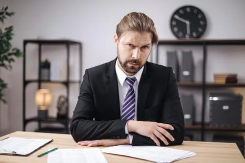 Businessman sitting at table with documents Stock Photos
