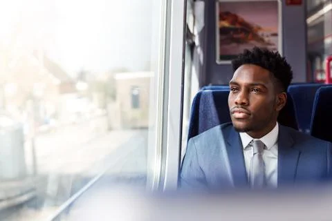 Businessman Sitting In Train Commuting To Work Looking Out Of Window Stock Photos