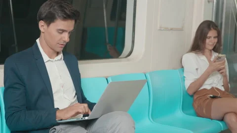 Businessman sitting using laptop computer working on the subway train Stock Footage 156880114