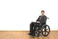 The businessman sitting in a wheelchair on the white wall background Photo