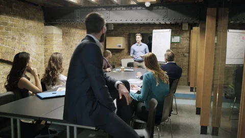 Businessman smiling at camera while colleagues have a meeting in background Stock Footage 107888680
