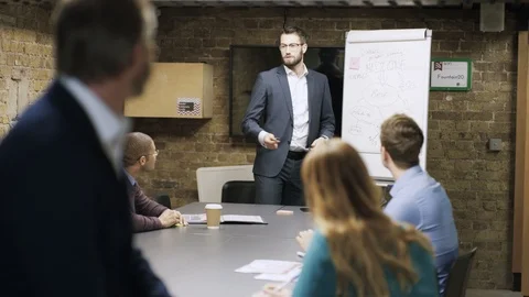 Businessman smiling at camera while colleagues have a meeting in background Video stock 107888860