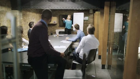 Businessman smiling at camera while colleagues have a meeting in background Stock Footage 107889044