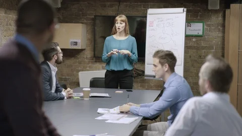 Businessman smiling at camera while colleagues have a meeting in background Stock Footage 107889222