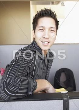 Businessman smiling over cubicle wall Stock Photos