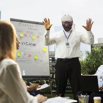 Businessman Smiling in Virtual Reality Headset During Team Demo Stock Photos