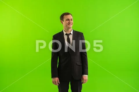 The businessman stand on the green background Stock Photos