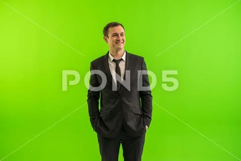The businessman stand on the green background Stock Photos