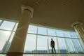 The businessman stand near panoramic window on the sunset background Photo