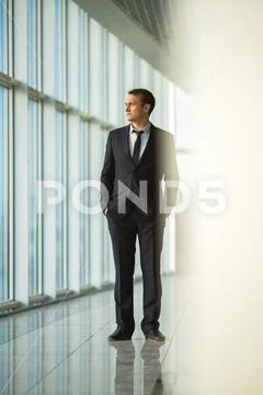 The businessman stand near the panoramic window Stock Photos