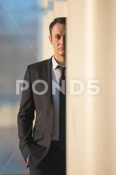 The businessman stand over the office column Stock Photos