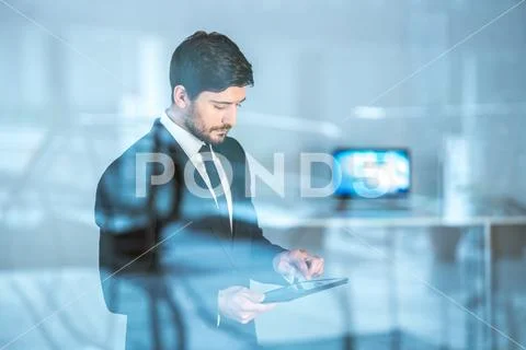 The businessman stand with the tablet over the window Stock Photos