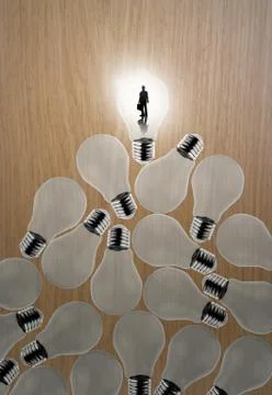 Businessman standing at 3d growing light bulb standing out from the unlit inc Stock Illustration