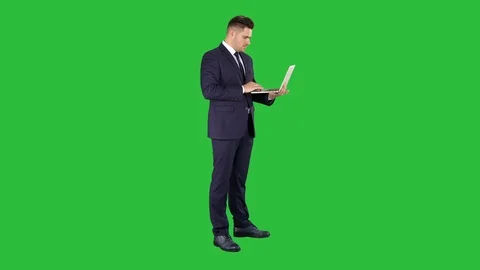 Businessman standing and using laptop on a Green Screen, Chroma Key. Stock Footage