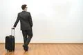 The businessman standing with a bag on the white wall background Photo