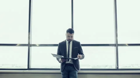 Businessman standing at the large window. Video stock 92733607
