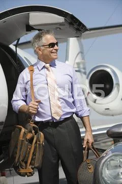Businessman Standing With Luggage At Airfield Stock Photos