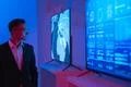 The businessman standing near screens in the dark room Photo